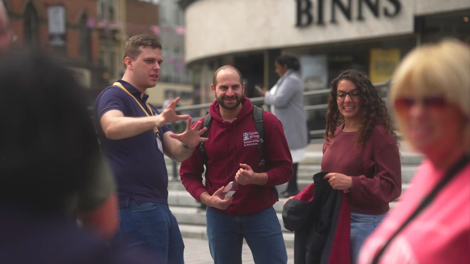 An image of Flippin' Pain team member Nathan showing two members of the public the Brain Bus