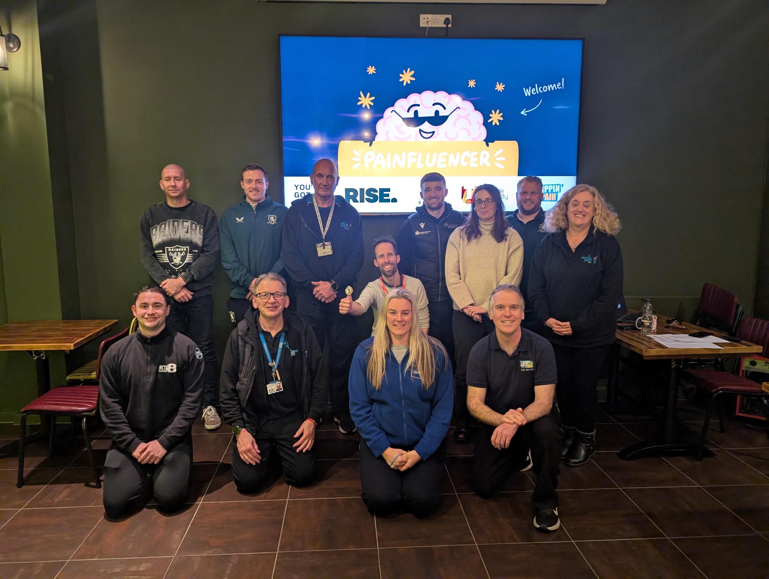 A photograph of a group of healthcare professionals standing and smiling.