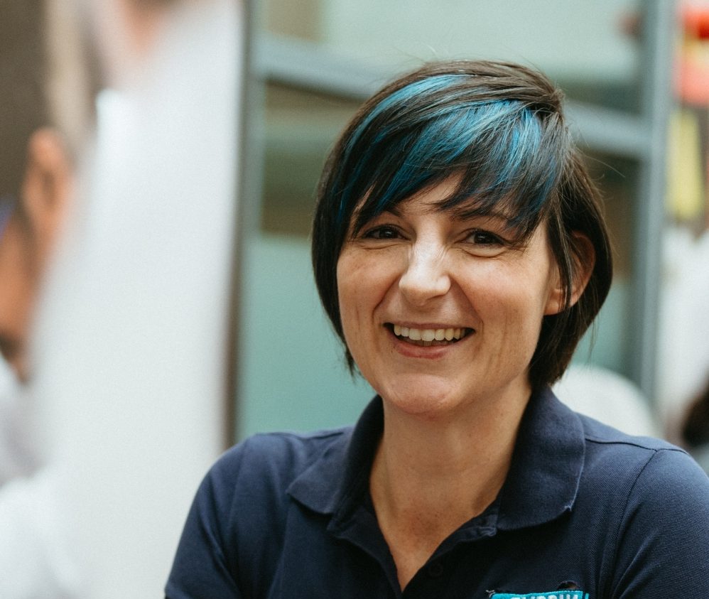 A photograph of a woman smiling wearing a Flippin' Pain top